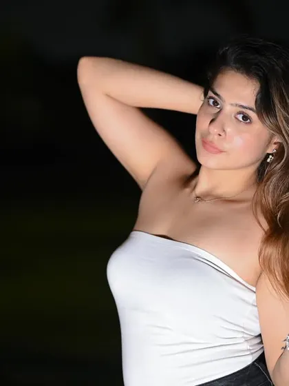 A striking close-up portrait shot at night. The flash isolates the model against the dark background, creating a dramatic and intimate feel.