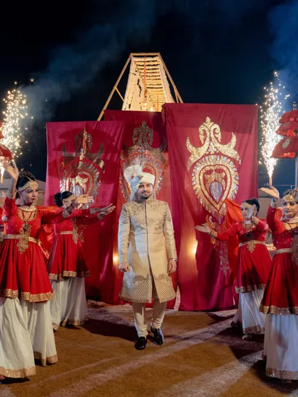 The groom's grand entry, flanked by dancers with red flags, creating a powerful and cinematic start to the ceremony.