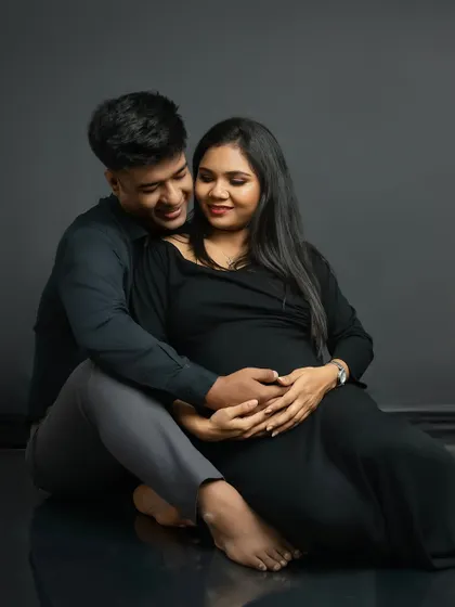 The same pose in color, highlighting the warmth and intimacy of the moment. The dark, simple outfits keep the focus on their expressions and connection.