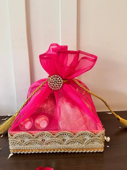 For a bold and beautiful statement, this rani pink Rakhi hamper is perfect. The rich color, combined with the elegant organza wrapping and traditional gota patti tray, makes it a truly special gift for a sibling.