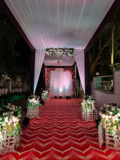 Looking down the elegant reception walkway, with its floral-adorned wooden crates and dramatic lighting.
