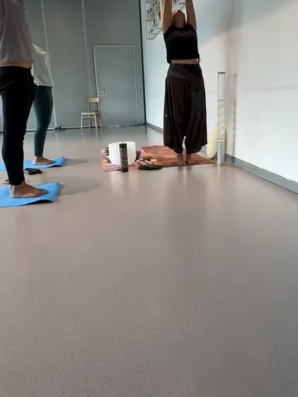 Participants in a standing side stretch during a corporate class. This simple pose helps to open up the side body and improve spinal flexibility.