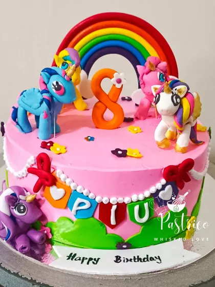 A colourful 'My Little Pony' cake with a rainbow and handcrafted pony figures for an 8th birthday celebration.