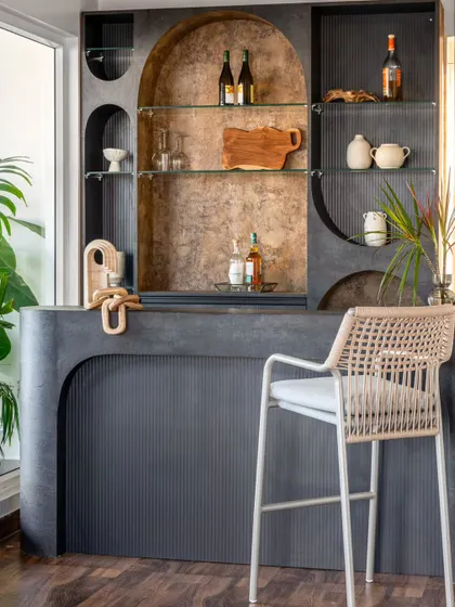 This bespoke bar, crafted from earthy stone and warm wood, is a calm retreat next to the verdant terrace. Its soft curves and thoughtful placement make it a perfect spot to unwind in the evening.