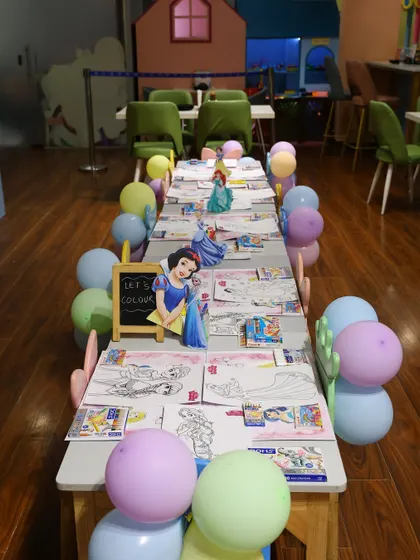 We can set up dedicated activity zones, like this princess coloring station. The long table is decorated with balloons and character cutouts to keep everything on-theme.