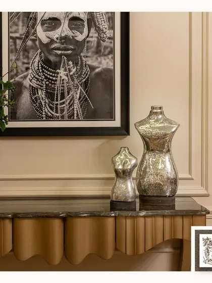 My collection often features unique and striking pieces like these silver glass mannequin sculptures. They add a touch of modern sophistication and artistic flair to a console table, paired here with tribal art.