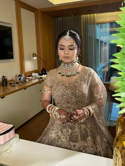 A moment of reflection for my bride Riya. Her makeup features a warm, brown-toned eyeliner and soft contouring to complement her exquisite ivory and golden lehenga.