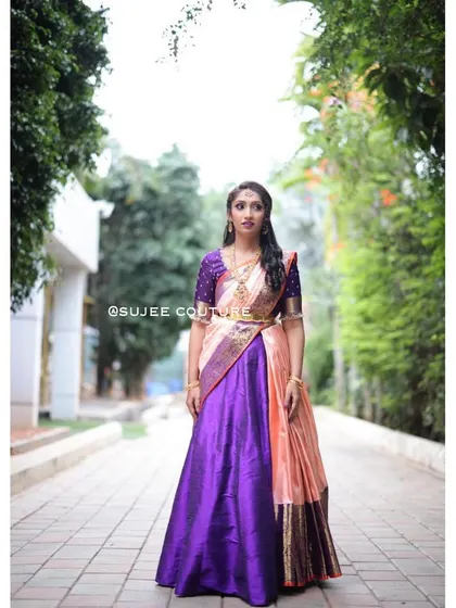 A modern take on a classic South Indian tradition. This custom Langa Voni set pairs a rich purple silk skirt with a contrasting peach half-saree and a beautifully embroidered blouse for a striking pre-wedding look.
