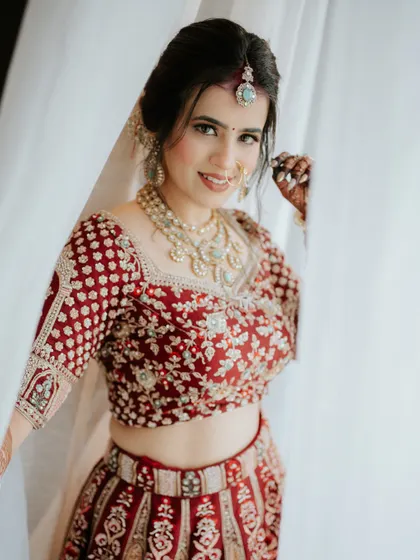 A bride peeks out from behind a curtain, her smile radiant. This shot captures her joyful anticipation and the beautiful details of her bridal look.
