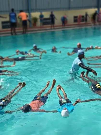 An instructor adjusts a participant's form during our Aqua Yoga session. We provide hands-on guidance to ensure everyone feels comfortable and gets the full benefit of the water-based practice.