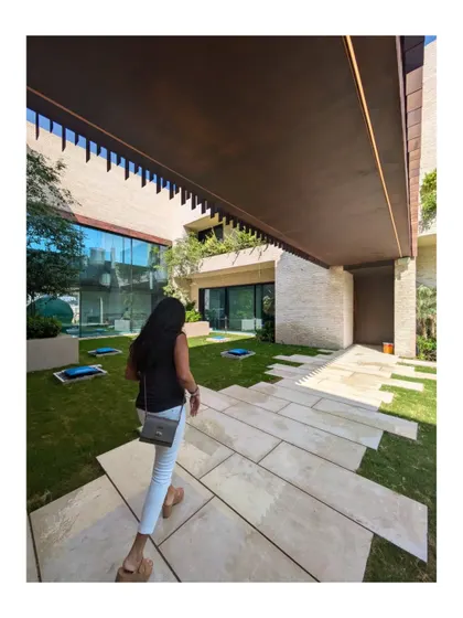 A resident walks through the courtyard of the Wahatan villa in Dubai Hills. The design creates a journey through interconnected indoor and outdoor spaces, all centered around a lush green oasis.