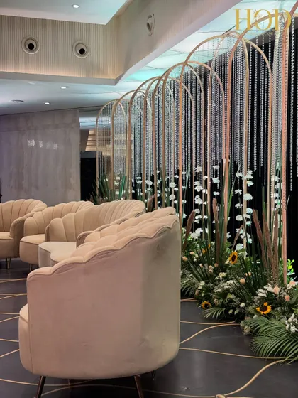 A side angle of the modern stage, showing the interplay of the arched backdrops, crystal strings, and the floral arrangements at the base.