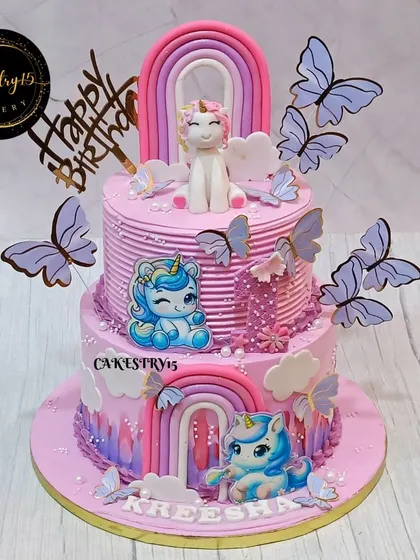 A beautiful 3kg two-tier unicorn-themed cake for a first birthday. This butterscotch cake is decorated with fondant unicorns, rainbows, and delicate butterflies in a lovely pink and purple design.