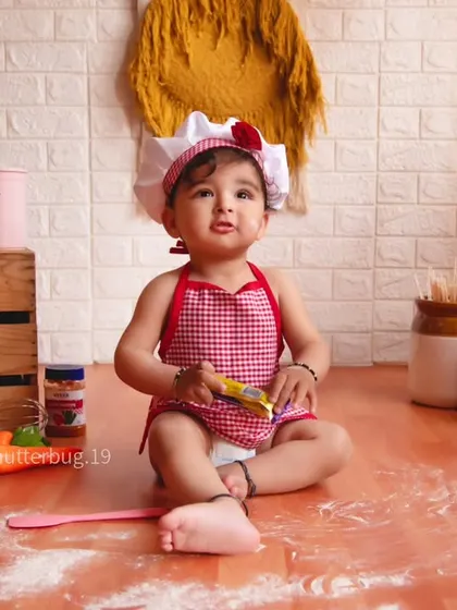 A cute shot of a baby sitting amidst a mess of flour, fully embracing the little chef role.