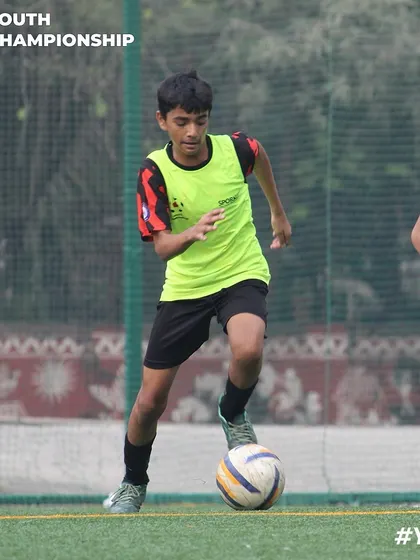 A young player in a training bib focused on his next move. This captures the concentration required during our skill development drills.
