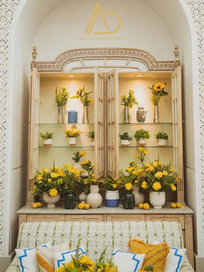 An entire cabinet filled with vibrant yellow floral arrangements and lemons, turning a simple piece of furniture into a stunning decor element.