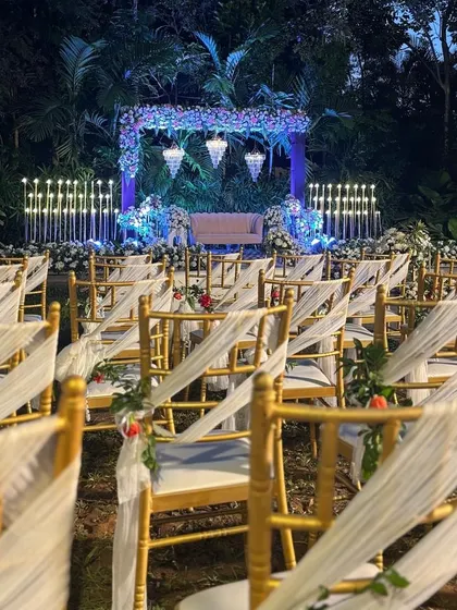 A view of the modern sangeet seating area, with elegant chairs and a beautifully lit stage in the background.