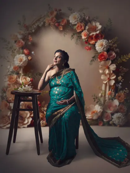 Whispers of beauty, a glimpse of grace. This shot is a delicate dance of light, color, and emotion, featuring a floral arch and a traditional saree.
