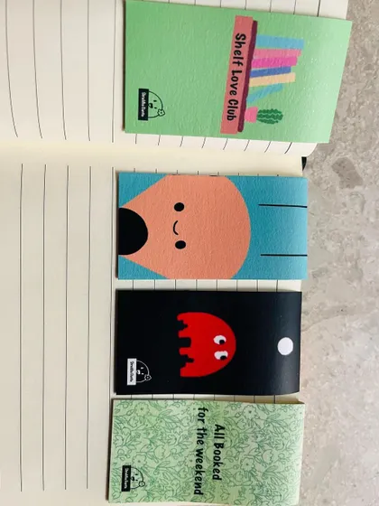 A vertical display of four different magnetic bookmark designs, showing their vibrant colors.