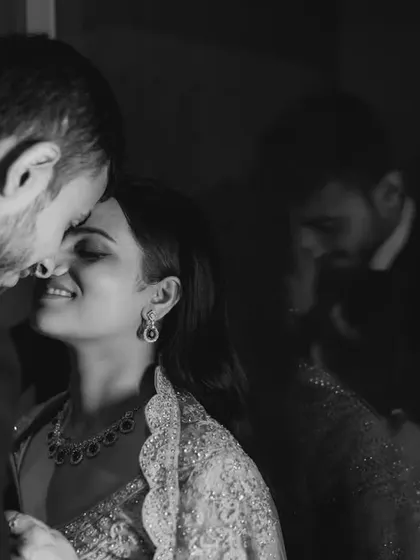 A romantic black and white portrait with a reflection. This artistic shot captures the couple's intimacy while adding a layer of depth and mood.