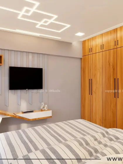 A bedroom from the 'Konark Oasis' project, showcasing a compact and functional design. The space includes a built-in wardrobe, a sleek study desk, and a stylish geometric ceiling light.