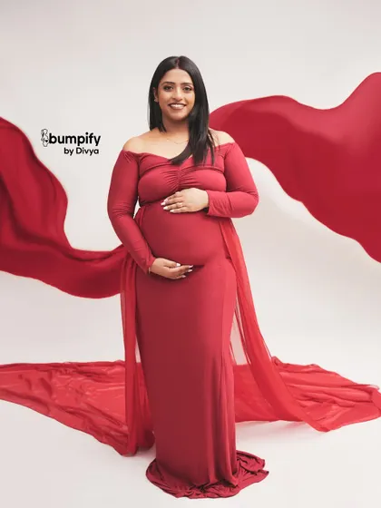 A classic and powerful portrait in red. We used a flowing red fabric to create a dramatic, wing-like effect behind the mom-to-be, making for a truly stunning image.