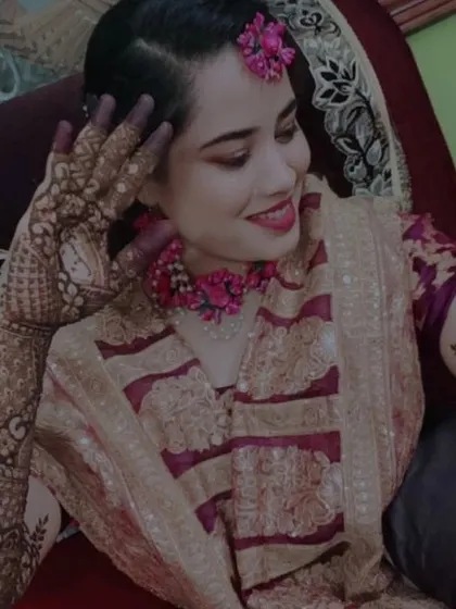 A graceful pose from the bride, giving a closer look at the detailed henna work on her hand and arm.