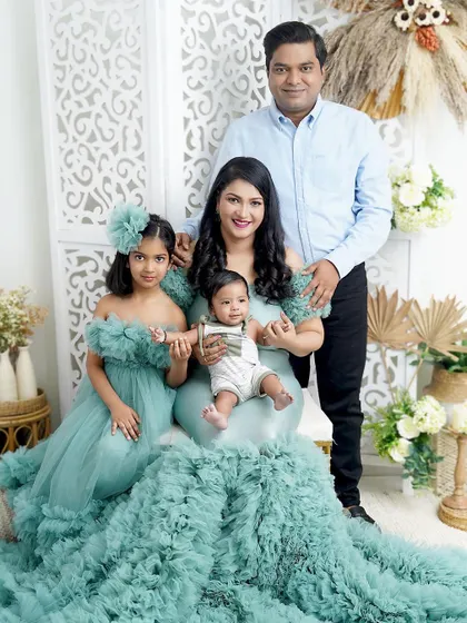 A family of four dressed in serene sea-green. The mother's incredible ruffled gown makes a stunning statement in this elegant family portrait.