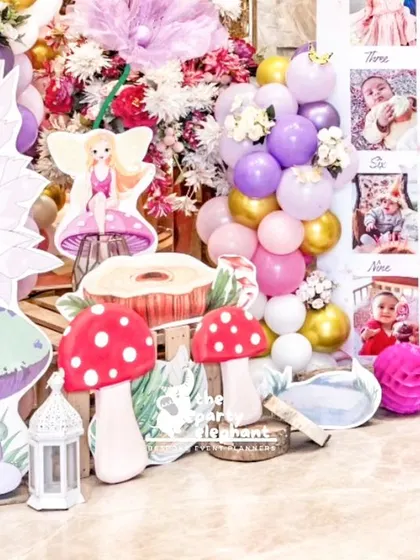 A detailed view of the props and milestone board, showing how we cluster elements like fairy cutouts, mushrooms, and balloons to create a visually rich display.