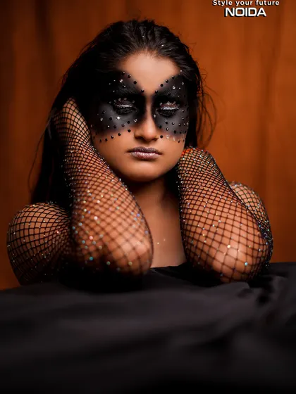 A serene pose with the black fantasy mask. The contrast between the dark makeup and the soft pose creates an interesting and artistic dynamic.