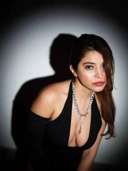 A close-up portrait from the same series, focusing on the model's intense gaze and the statement chain necklace.