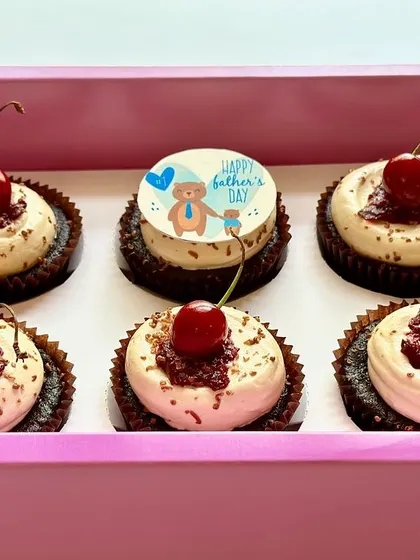 A box of our special Father's Day Black Forest cupcakes. Each cupcake is topped with vanilla buttercream, homemade cherry compote, chocolate flakes, and a fresh cherry for a classic and delicious treat.