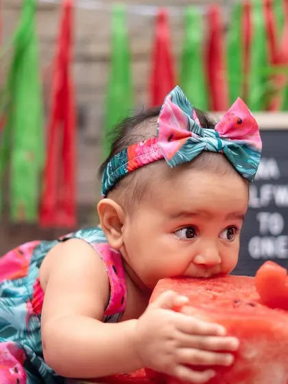 Getting a close-up look at her watermelon "cake". These sensory experiences create the most authentic and adorable expressions during a milestone session.