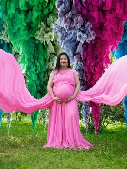 A creative and colorful maternity photo. Our pink flying gown stands out beautifully against this vibrant, edited background.