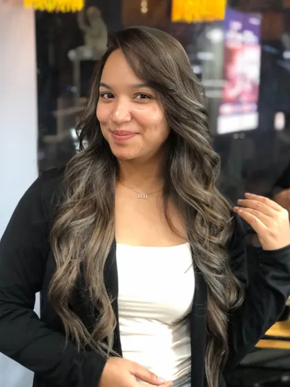A happy client showing off her new platinum blonde balayage. The cool tones and soft waves create a truly elegant and modern hairstyle.