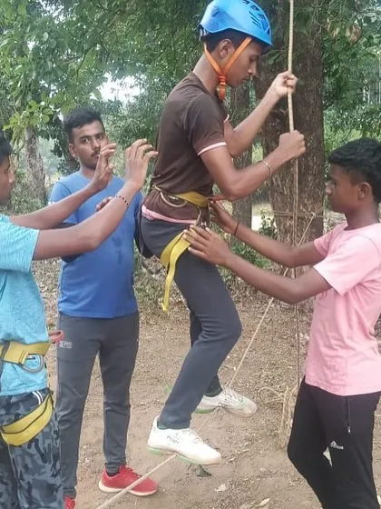 Instructors assist a young participant with his harness during a Tyrolean traverse exercise at our Barapole adventure camp.