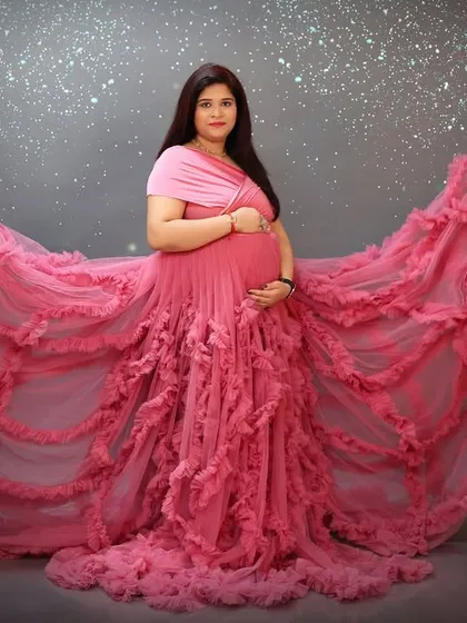 A powerful and dramatic pose. The sleeves of this pink gown are fanned out to create a wing-like effect, set against a sparkling, starry background for a touch of magic.