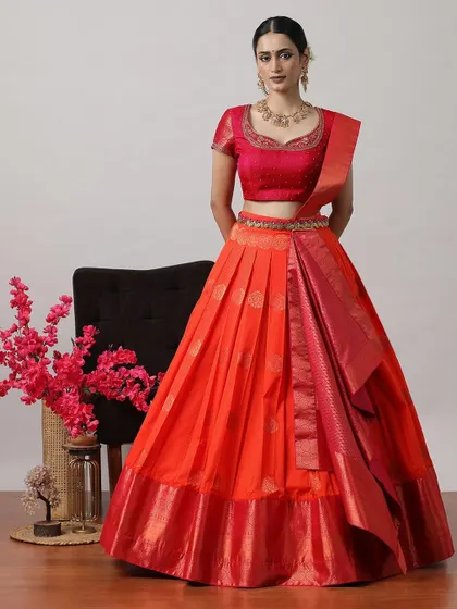 A bright orange-red lehenga with a matching blouse and Banarasi dupatta, perfect for making a bold statement.