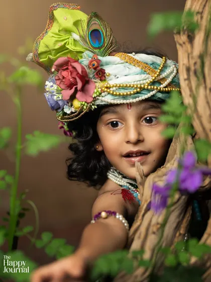A duplicate of image 114, a creative and playful shot of little Krishna peeking out from behind a tree.