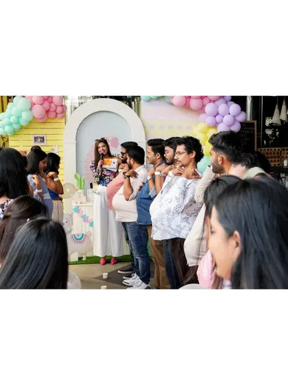 Fun and games are a key part of any baby shower. Here, guests participate in a playful activity, adding to the laughter and joy of the celebration.