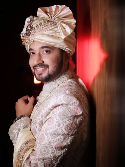 A stylish groom's portrait with dramatic red backlighting. This kind of creative lighting makes for a modern and memorable photo.