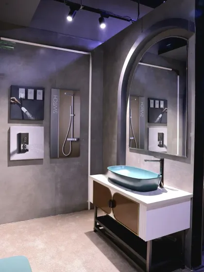 Another view of the teal-themed display, showing the modern vanity and the arched mirror that complements the design.
