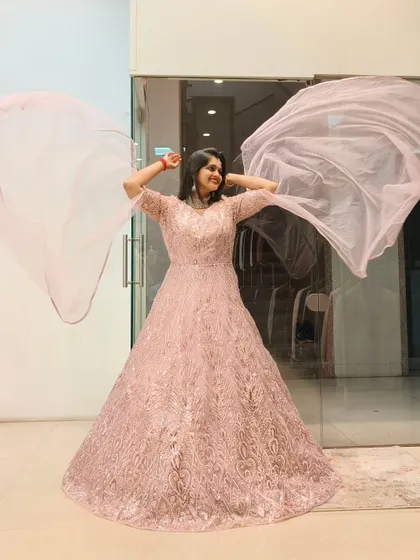 Feel like you're floating in a dream with this ethereal pink gown. The delicate embroidery and flowing fabric are perfect for a reception or engagement, ensuring you sparkle with every step and twirl.