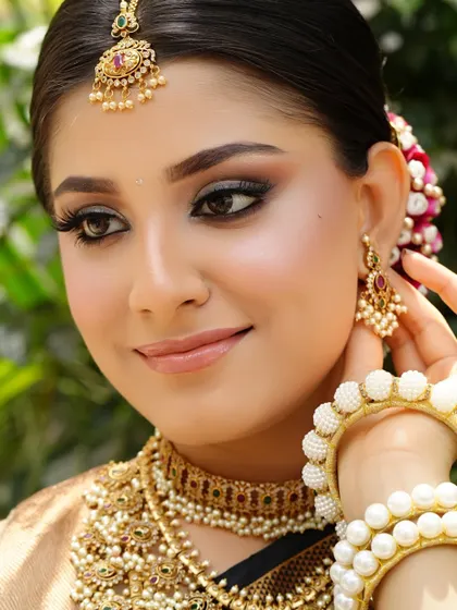 Embracing tradition with a touch of modern glam. This South Indian bridal look features classic temple jewelry, a neat hair bun with flowers, and sharp, defined eye makeup.