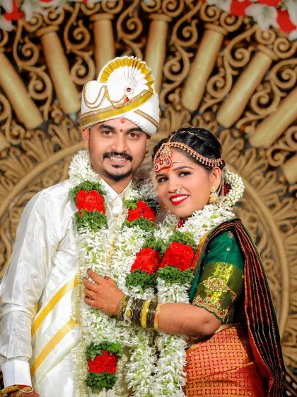 A classic portrait of the bride and groom in their wedding attire, smiling happily for the camera.