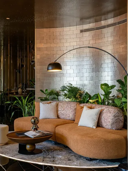 This is our vision for the modern workplace: The Midas Lounge, an office with no workstations. We used a curved sofa, metallic-finish brick tiles, and lush biophilic elements to design a space for connection and creativity, not just work.