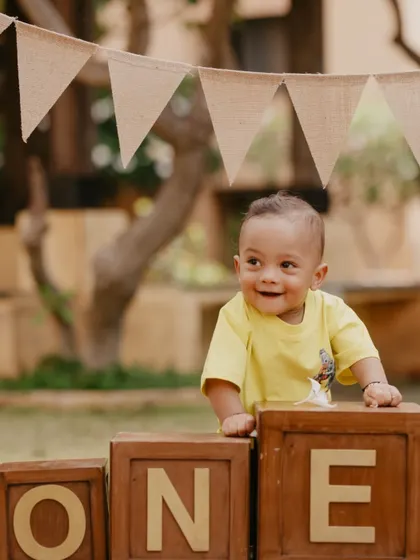 A sweet, happy smile from the birthday boy as he plays with his "ONE" blocks during his outdoor pre-birthday photoshoot.