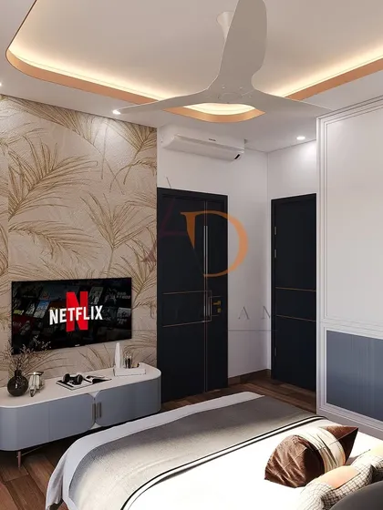 A wider view of the bedroom, showing the TV wall, dual-tone wardrobes, and the warm cove lighting in the ceiling that adds a cozy ambiance.
