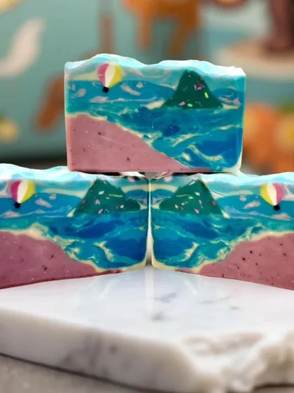 Capturing the energy of the ocean in a bar of soap. This beach-themed design features swirling waves, a pink sand shore, and even a tiny hot air balloon.
