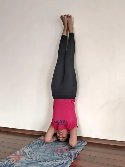 Practicing Sirsasana (Headstand) against the wall is an essential step in learning this powerful inversion safely.